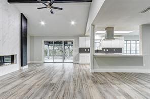 unfurnished living room with a large fireplace and light hardwood / wood-style flooring