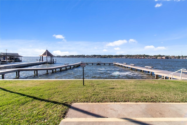 dock area with a lawn and a water view