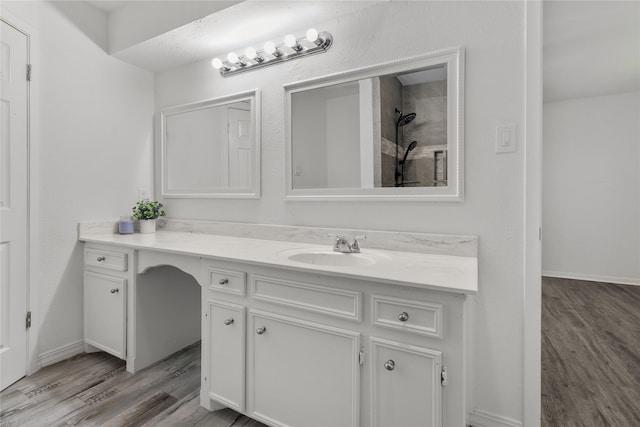 bathroom featuring vanity, walk in shower, and wood-type flooring