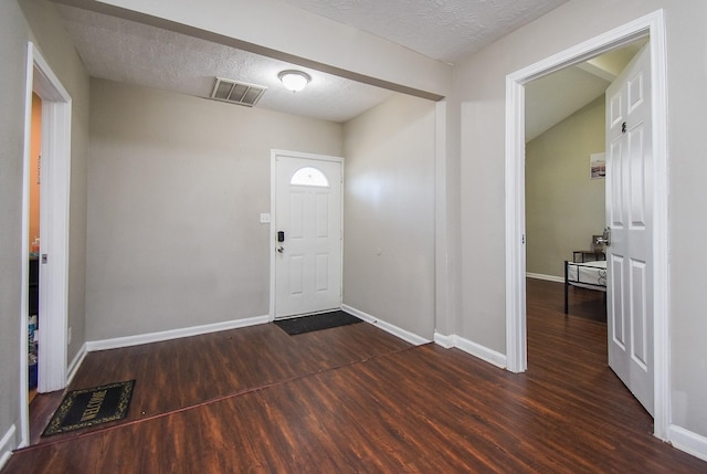 entrance foyer featuring dark hardwood / wood-style floors and a textured ceiling