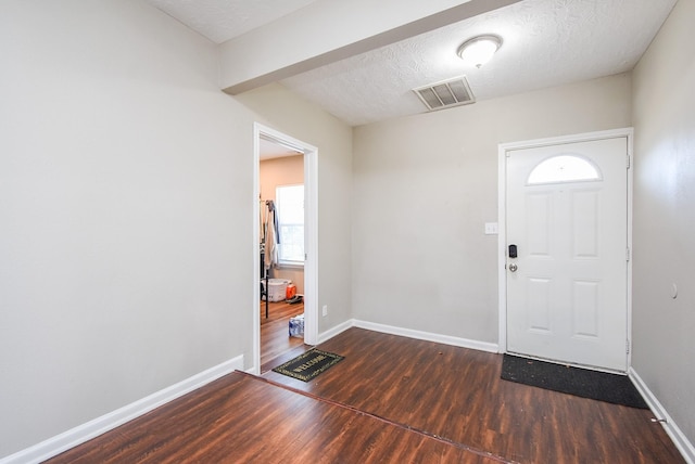 foyer featuring dark hardwood / wood-style flooring and a textured ceiling