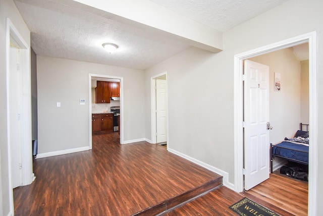 corridor with dark wood-type flooring and a textured ceiling