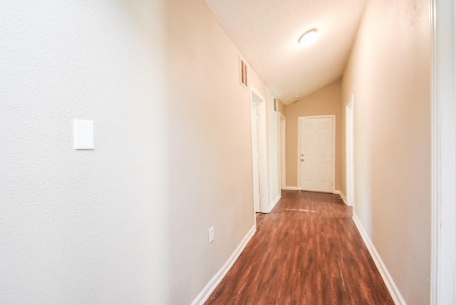 corridor featuring vaulted ceiling and dark hardwood / wood-style flooring