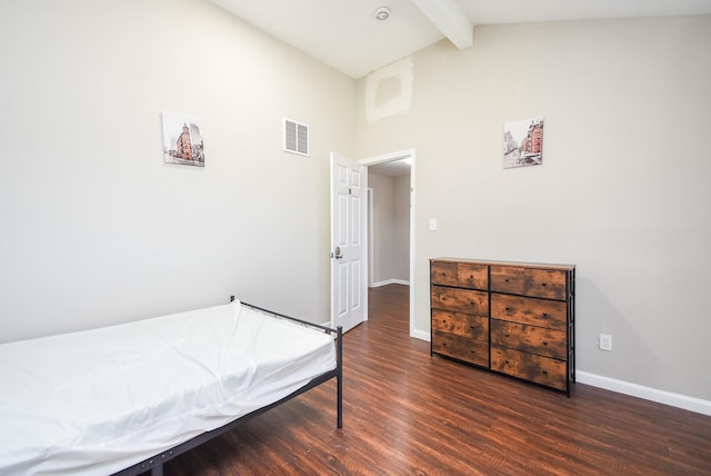 bedroom featuring dark wood-type flooring and vaulted ceiling with beams