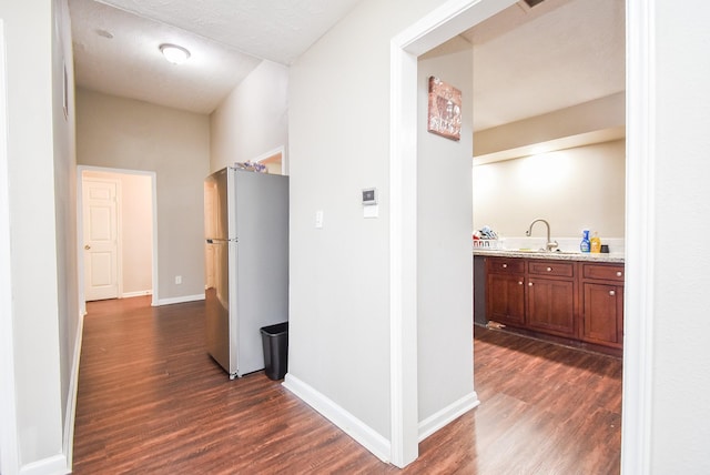 corridor with sink and dark wood-type flooring