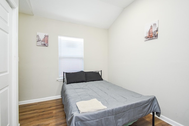 bedroom featuring multiple windows, vaulted ceiling, and dark hardwood / wood-style floors