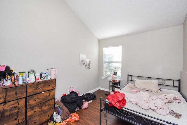 bedroom with vaulted ceiling and dark hardwood / wood-style flooring