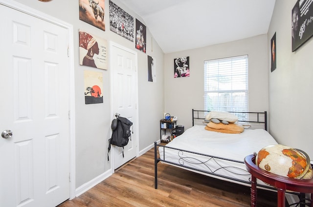 bedroom featuring vaulted ceiling and hardwood / wood-style floors