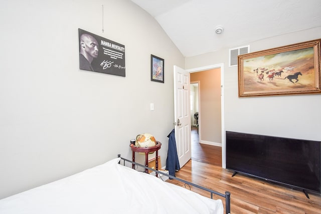 bedroom with vaulted ceiling and hardwood / wood-style floors