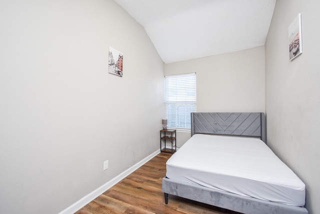 bedroom featuring dark hardwood / wood-style flooring and lofted ceiling