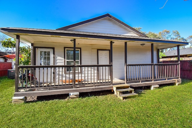 back of house featuring covered porch and a lawn