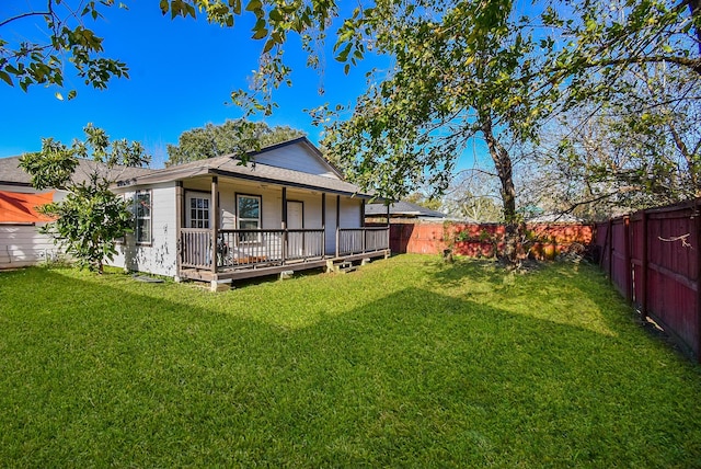 rear view of property with a wooden deck and a lawn