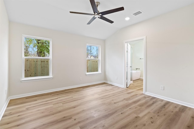 unfurnished room with ceiling fan, light wood-type flooring, a wealth of natural light, and vaulted ceiling