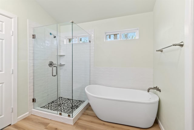 bathroom featuring wood-type flooring, tile walls, and plus walk in shower