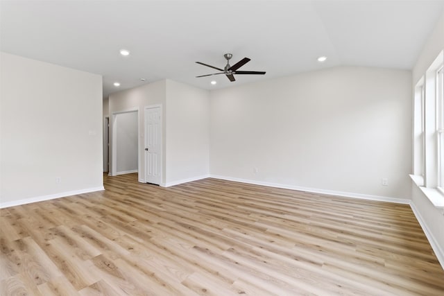 empty room with ceiling fan, vaulted ceiling, and light hardwood / wood-style flooring