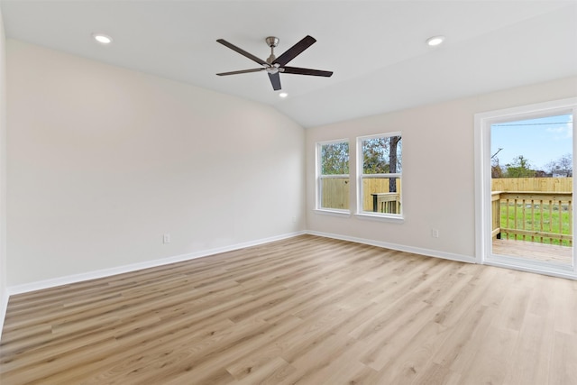 empty room with ceiling fan, lofted ceiling, and light wood-type flooring