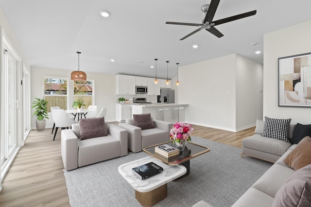 living room featuring ceiling fan and light wood-type flooring