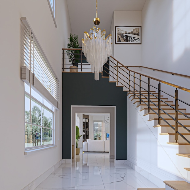 foyer entrance with plenty of natural light, a towering ceiling, and an inviting chandelier