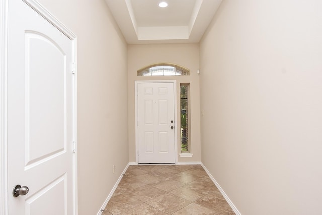 doorway to outside featuring a raised ceiling and a wealth of natural light