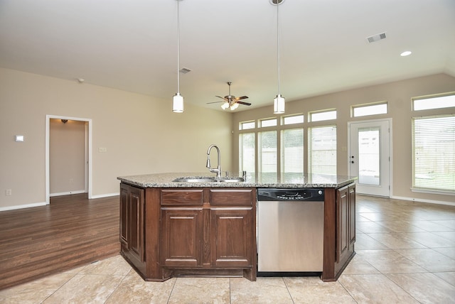 kitchen featuring light stone countertops, sink, ceiling fan, stainless steel dishwasher, and a kitchen island with sink