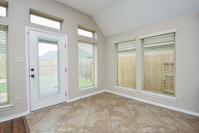 entryway with light tile patterned floors and lofted ceiling