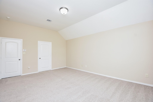 empty room with carpet floors and vaulted ceiling