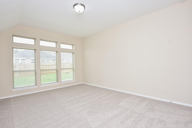 carpeted spare room with lofted ceiling