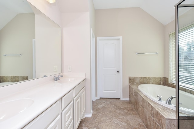 bathroom with vanity, lofted ceiling, and tiled tub