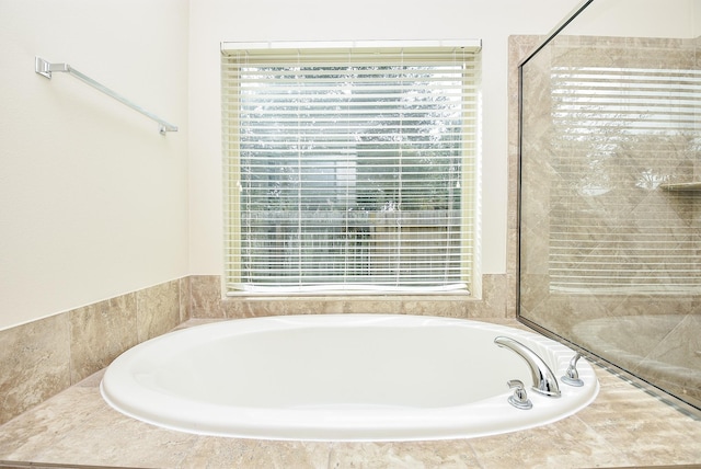 bathroom featuring a relaxing tiled tub