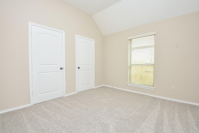 unfurnished bedroom featuring carpet flooring and vaulted ceiling