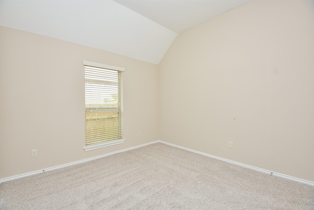 carpeted empty room with lofted ceiling