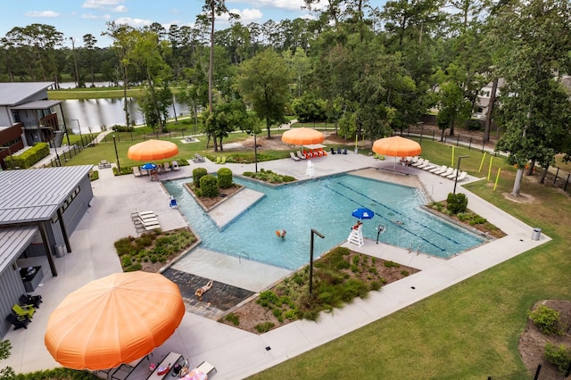 view of pool with a patio area, a water view, and a yard