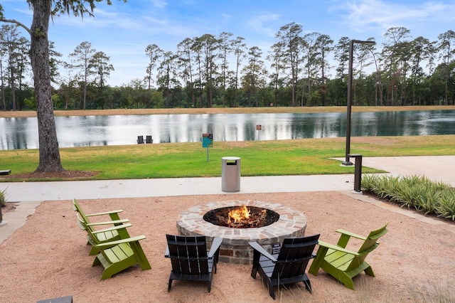 surrounding community featuring a fire pit, a water view, and a yard