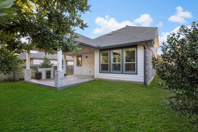 rear view of property with a yard and a patio