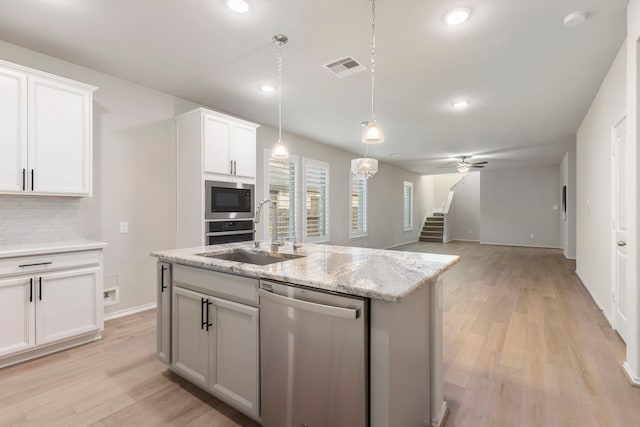 kitchen with white cabinets, stainless steel dishwasher, ceiling fan, and sink