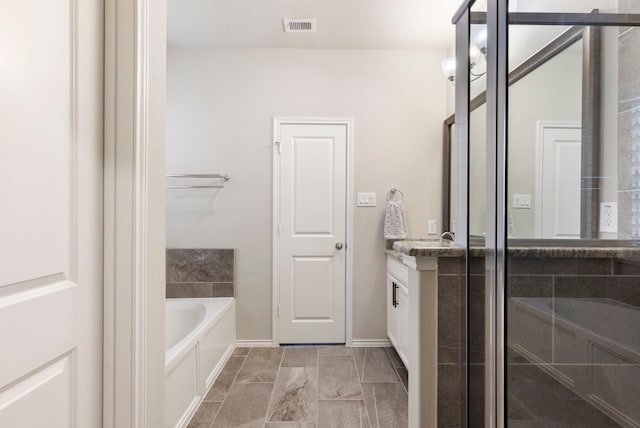 bathroom with vanity and shower with separate bathtub