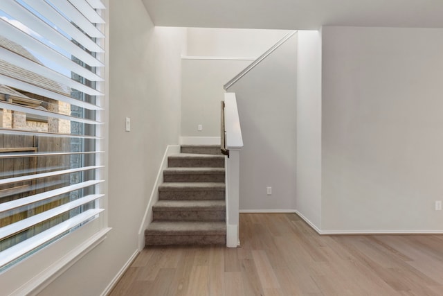 staircase featuring a healthy amount of sunlight and hardwood / wood-style flooring