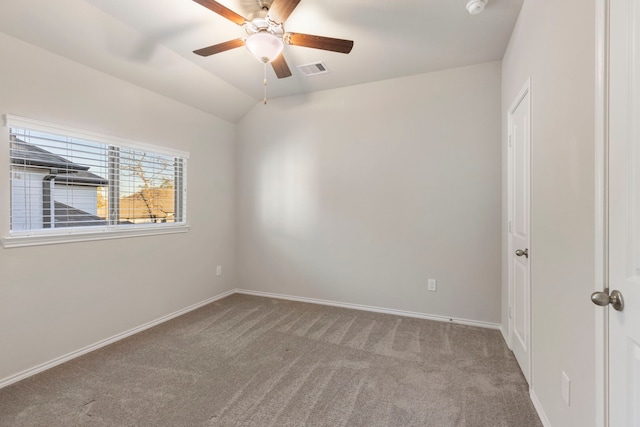 spare room with light colored carpet, vaulted ceiling, and ceiling fan