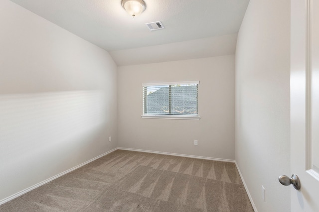 spare room with carpet floors and vaulted ceiling