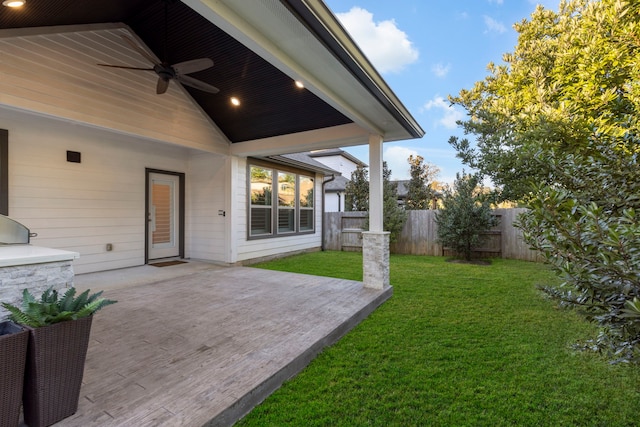 view of yard with ceiling fan and a patio