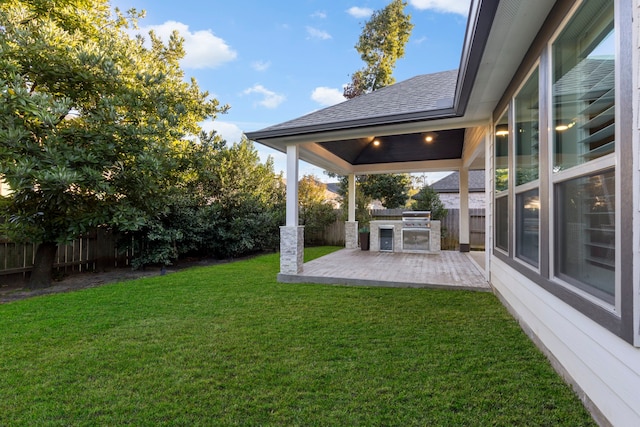 view of yard featuring an outdoor kitchen and a patio