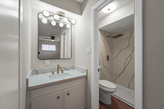 bathroom with vanity, ceiling fan, a shower, hardwood / wood-style flooring, and toilet