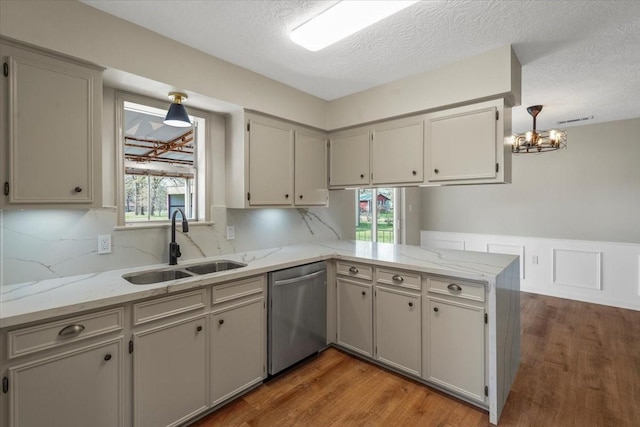 kitchen with kitchen peninsula, stainless steel dishwasher, gray cabinetry, sink, and dark hardwood / wood-style floors