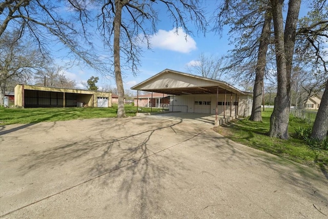 view of front of property featuring a carport and an outdoor structure