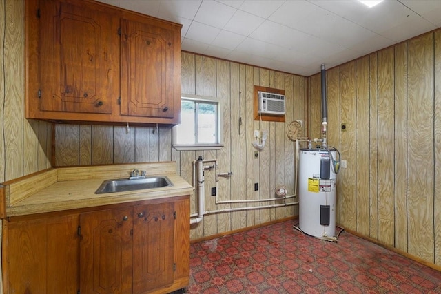 interior space with dark carpet, electric water heater, a wall unit AC, sink, and wood walls