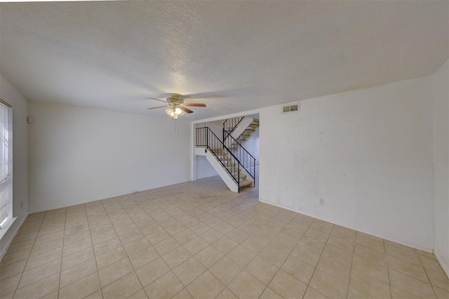 empty room featuring ceiling fan and a textured ceiling