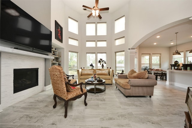 living room with a high ceiling, a healthy amount of sunlight, and ceiling fan