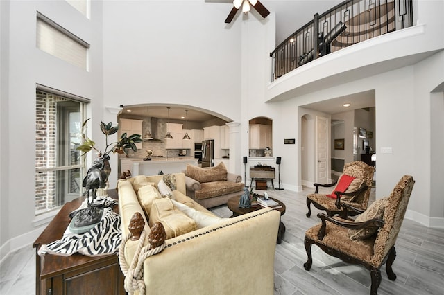 living room featuring ceiling fan and a towering ceiling