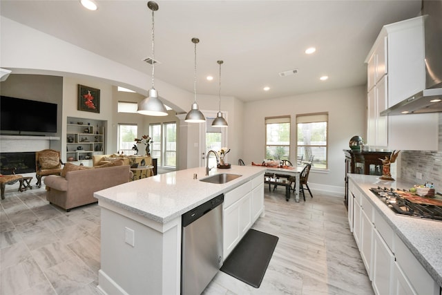 kitchen featuring sink, white cabinetry, hanging light fixtures, appliances with stainless steel finishes, and a kitchen island with sink