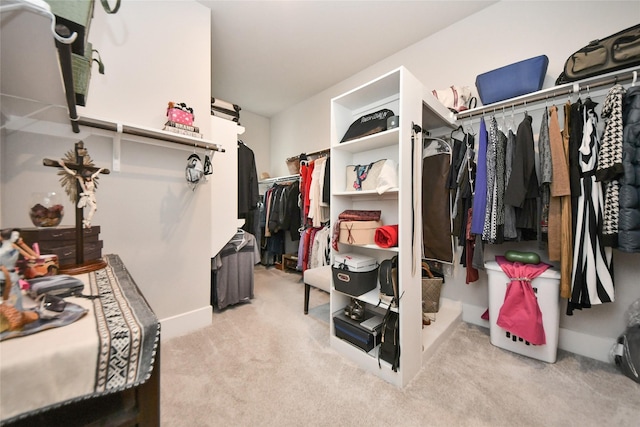 walk in closet featuring light colored carpet